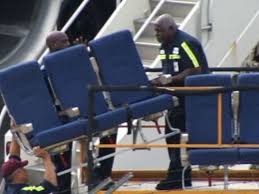 workmen carrying airplane seats